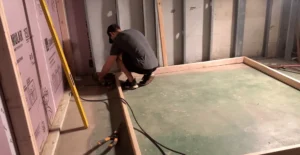 Person framing out a basement wall to finish a concrete basement. Hire a professional contractor to ensure your basement remodeling is done right the first time.